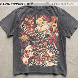 May include: A charcoal gray short-sleeve t-shirt featuring a vintage-style Christmas graphic. The design includes a reindeer, Santa Claus, a nutcracker, a snowman, a decorated tree, gifts, and candy canes with a black and white checkered ribbon.