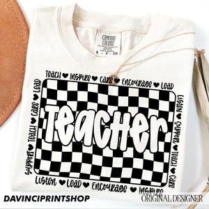 May include: A white t-shirt with a black and white checkered design and the word "Teacher" in a bold, white font. The words "Support, Teach, Care, Lead, Listen, Lead, Encourage, Inspire" are printed around the checkered design.