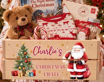 May include: A wooden crate labelled Charlie's Christmas Crate featuring a Santa Claus and Christmas tree graphic. Inside are a brown teddy bear with a plaid bow, a book titled The Night Before Christmas, reindeer pyjamas, a candy cane, and a jar.