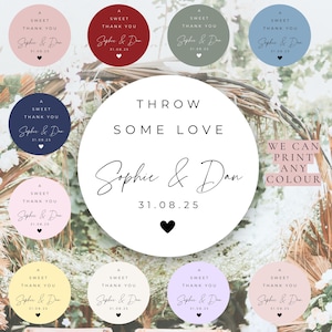 Könnte beinhalten: Eine Sammlung runder Aufkleber in verschiedenen Farben, jeweils mit dem Text "A Sweet Thank You" und den Namen "Sophie & Dan" sowie dem Datum "31.08.25". Das zentrale Design lautet "Throw Some Love".