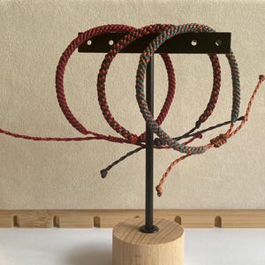 Pulsera ajustable con cordón de nailon trenzado a mano.