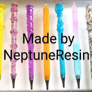 May include: A collection of ten colorful resin pens with glitter and various designs. The pens are made by NeptuneResin.