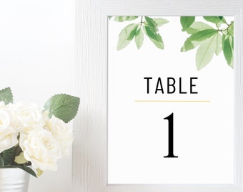 May include: White frame with a green leaf design and the text "TABLE 1" in black.