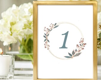 May include: Gold frame table number with a white background and a gold circle with a blue number 1 and a floral design in shades of blue and pink.