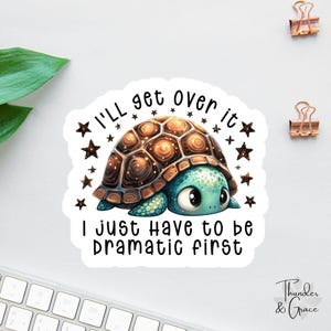 May include: A sticker featuring a cartoon turtle with a brown shell and a turquoise face. The text "I'll get over it, I just have to be dramatic first" is written on the sticker, surrounded by stars.