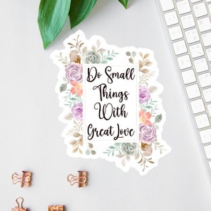 Puede incluir: Una pegatina blanca con un borde floral y el texto "Do Small Things With Great Love" en negro.