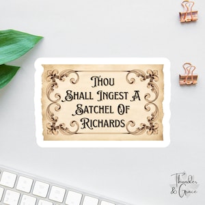 May include: A sticker with the text "Thou Shall Ingest A Satchel Of Richards" in a vintage style. The sticker has a parchment-like background with ornate brown scrollwork around the edges. The sticker is on a white surface.