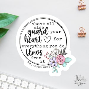 May include: A round sticker with the text "above all else guard your heart for everything you do flows from it Proverbs 4:23". The sticker has a floral design with pink, purple, and blue flowers.