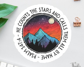 Può includere: Un adesivo rotondo con un paesaggio montano e un cielo notturno. Il design include una luna piena, stelle e alberi. Il testo sul bordo recita: "Egli conta le stelle e le chiama tutte per nome - Salmo 147:4."