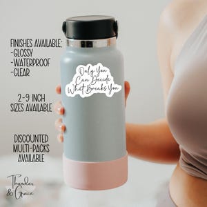 Puede incluir: Una botella de agua gris con una tapa rosa y una pegatina blanca que dice "Only You Can Decide What Breaks You".
