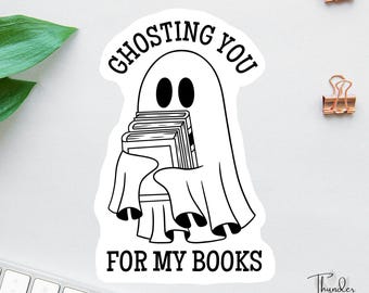 Könnte beinhalten: Ein schwarz-weißer Aufkleber mit einem Cartoon-Geist, der Bücher hält. Der Text auf dem Aufkleber lautet „Ghosting You For My Books“. Der Aufkleber hat einen weißen Hintergrund und ist von einem schwarzen Rand umgeben.