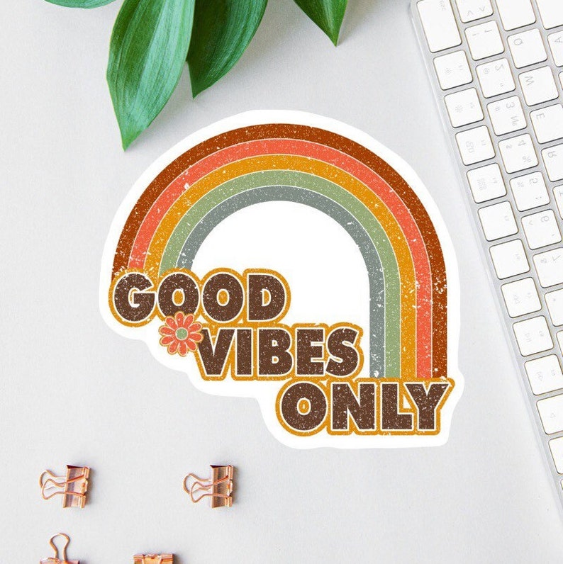 May include: A sticker with a rainbow design and the text "GOOD VIBES ONLY" in brown letters with a flower graphic.