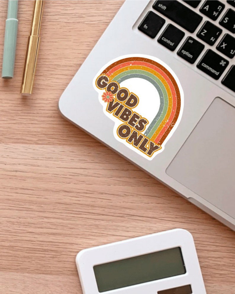 May include: A sticker with a rainbow design and the text "GOOD VIBES ONLY" in brown letters with a small flower graphic.