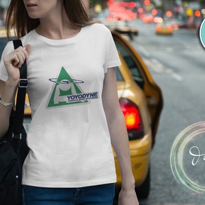 May include: White t-shirt with a green triangle logo that says "Yoyodyne" and "People Who Think" in blue text.