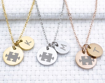 May include: Three gold, silver, and rose gold necklaces with puzzle piece pendants and initial charms. The initials are K, M, and T.