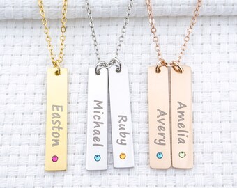 May include: Four gold, silver, and rose gold necklaces with personalized name bars. Each bar has a small gemstone accent. The names on the bars are Easton, Michael, Ruby, Avery, and Amelia.