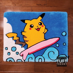 Può includere: Un personaggio dei cartoni animati Pikachu giallo che cavalca un surf rosa su un'onda blu con schiuma bianca. Lo sfondo è blu con nuvole bianche e bolle blu e bianche. Il tappeto ha il testo "TUFT THEORY" nell'angolo in basso a destra.
