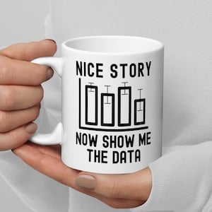 Puede incluir: Taza de cerámica blanca con un gráfico negro que dice "Nice story now show me the data" y un gráfico de barras con cinco barras.