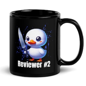 Può includere: Tazza in ceramica nera con un'anatra dei cartoni animati che tiene un coltello, con la scritta "Reviewer #2". L'anatra è bianca con becco rosso e zampe arancioni, su uno sfondo a spruzzi blu.