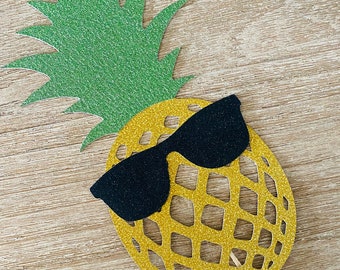 May include: A yellow pineapple with a black glitter sunglasses cutout. The pineapple is made of glitter paper and has a green glitter paper top.