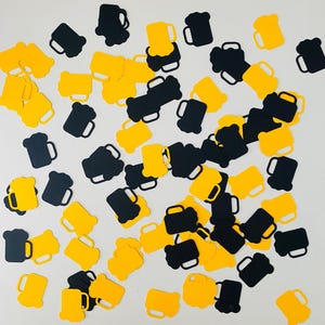 Peut inclure: Confettis en forme de chopes de bière jaunes et noires éparpillées. Les découpes, de tailles et d'orientations variées, créent un arrangement ludique et festif. Les chopes ont une anse classique.