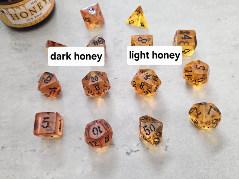 May include: A set of 10 dice in two shades of amber, labeled with black numbers. The dice are labeled "dark honey" and "light honey".