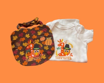 Puede incluir: Un babero marrón con un diseño de pavo y hojas y el texto "My 1st Thanksgiving". Un body blanco con un diseño de pavo y hojas y el texto "My 1st Thanksgiving".