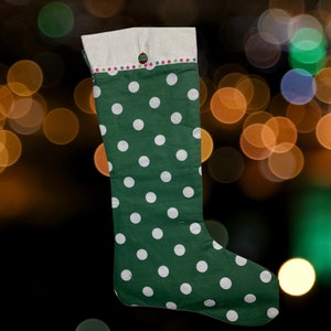 May include: Green Christmas stocking with white polka dots and a white cuff with a red and green ornament design.