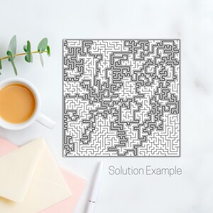 May include: A black and white maze design with the text "Solution Example". The maze is complex and intricate, with a network of paths. A cup of coffee, a pen, and envelopes are also in the image.
