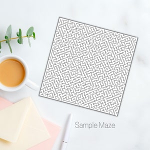 May include: A white square maze printed with a complex black line design. The words "Sample Maze" are printed in a gray font at the bottom. A cup of coffee, a pen, and envelopes are also in the image.