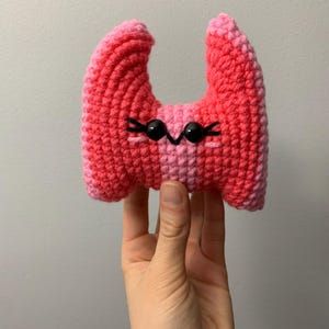 May include: A white ceramic mug with a black handle and the text "But First, Coffee" in a black, handwritten-style font. The mug is on a white surface.