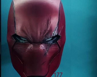 May include: A full-face red helmet featuring a smooth, rounded top and angular eye openings. The surface displays subtle, weathered scratch marks across the forehead and cheek areas. The text 1ZZ is printed in red near the bottom right.