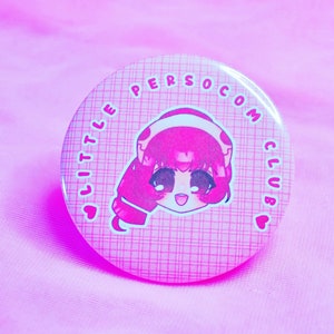 Peut inclure: Bouton rose avec un personnage de dessin animé portant un casque et le texte "Little Persocom Club" autour du bord.