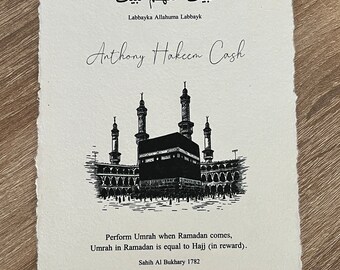 May include: A black and white illustration of the Kaaba, a cube-shaped building in Mecca, Saudi Arabia. The text reads "Umrah Ramadan 1445/2024" and "Labbayka Allahuma Labbayk". The name "Anthony Hakeem Cash" is written in cursive below the illustration. The text below the illustration reads "Perform Umrah when Ramadan comes, Umrah in Ramadan is equal to Hajj (in reward). Sahih Al Bukhary 1782".