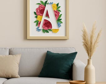 Può includere: Un'artigianato di carta incorniciato con la lettera A circondata da fiori di carta colorati in tonalità rosa, giallo e blu.