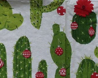 May include: A white background with a repeating pattern of green cactus plants with red and white Christmas ornaments. The cactus plants have a red flower on top.