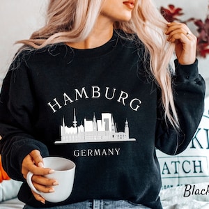 May include: Black sweatshirt with a white graphic of the Hamburg skyline and the text "Hamburg Germany".