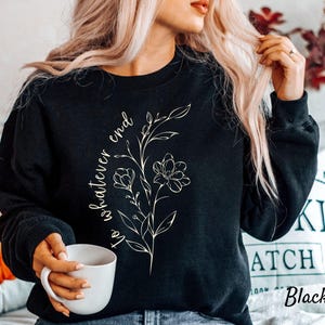May include: Black sweatshirt with a white floral design and the text "to whatever end" printed on the front.