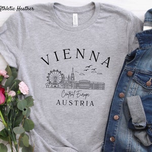May include: Grey t-shirt with a black graphic of the Vienna skyline, including the Ferris wheel, St. Stephen's Cathedral, and the text "VIENNA, Central Europe, AUSTRIA".