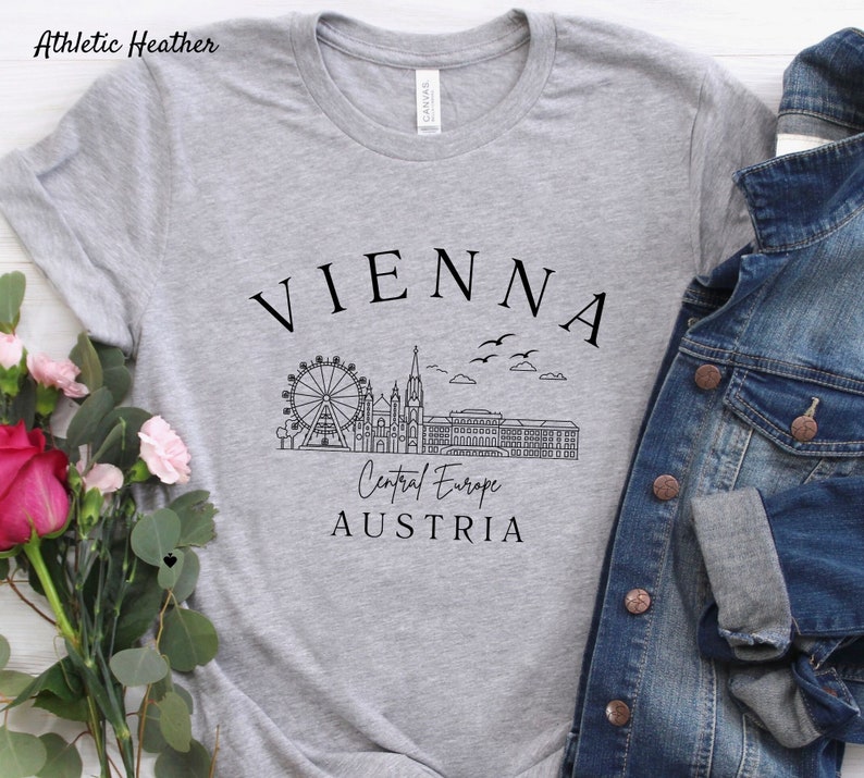 May include: Grey t-shirt with a black graphic of the Vienna skyline, including the Ferris wheel, St. Stephen's Cathedral, and the text "VIENNA, Central Europe, AUSTRIA".