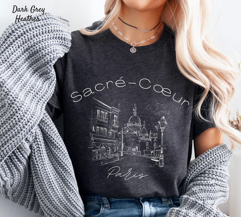 K&ouml;nnte beinhalten: Dunkelgraues meliertes T-Shirt mit einer wei&szlig;en Strichzeichnung der Basilika Sacr&eacute;-C&oelig;ur in Paris. Die W&ouml;rter "Sacr&eacute;-Coeur" und "Paris" sind ebenfalls in Wei&szlig;. Das T-Shirt hat einen Rundhalsausschnitt und kurze &Auml;rmel.