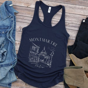 May include: A navy blue tank top featuring a white graphic of a Parisian street scene with the text "Montmartre, Paris".