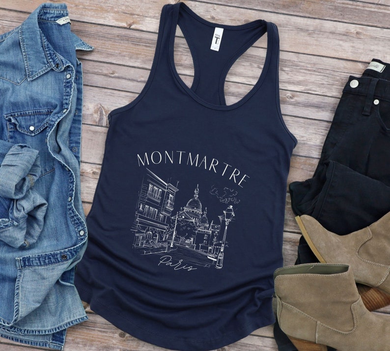 May include: A navy blue tank top featuring a white graphic of a Parisian street scene with the text "Montmartre, Paris".