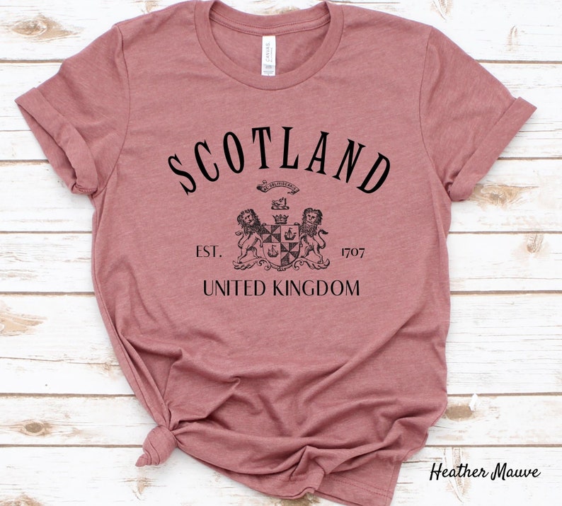 May include: Heather mauve t-shirt with black text that reads "Scotland Est. 1707 United Kingdom" and a black and white crest with two lions.