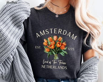May include: Dark grey heather t-shirt with a graphic print of a bouquet of orange tulips. The text "AMSTERDAM EST. 1275 Land of the Tulips NETHERLANDS" is printed on the shirt.
