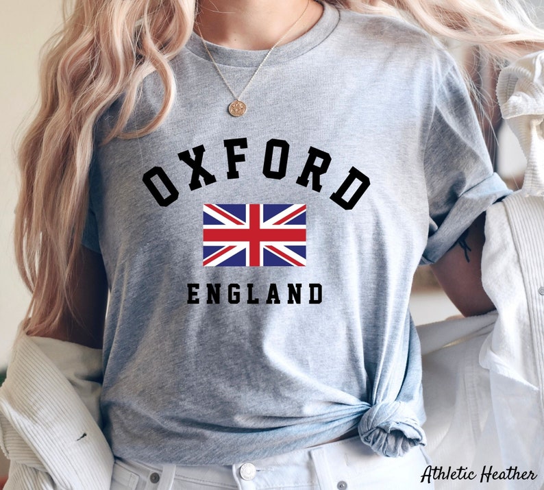 Puede incluir: Camiseta gris con texto negro que dice "Oxford England" y una bandera de la Uni&oacute;n Jack roja, blanca y azul.