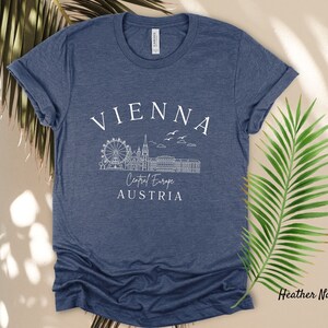 May include: Heather navy blue t-shirt with a white graphic of the Vienna skyline, including the Ferris wheel, and the text "Vienna, Central Europe, Austria".