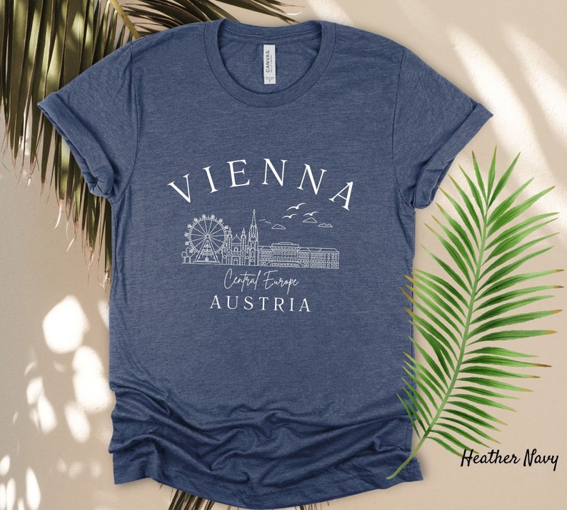 May include: Heather navy blue t-shirt with a white graphic of the Vienna skyline, including the Ferris wheel, and the text "Vienna, Central Europe, Austria".