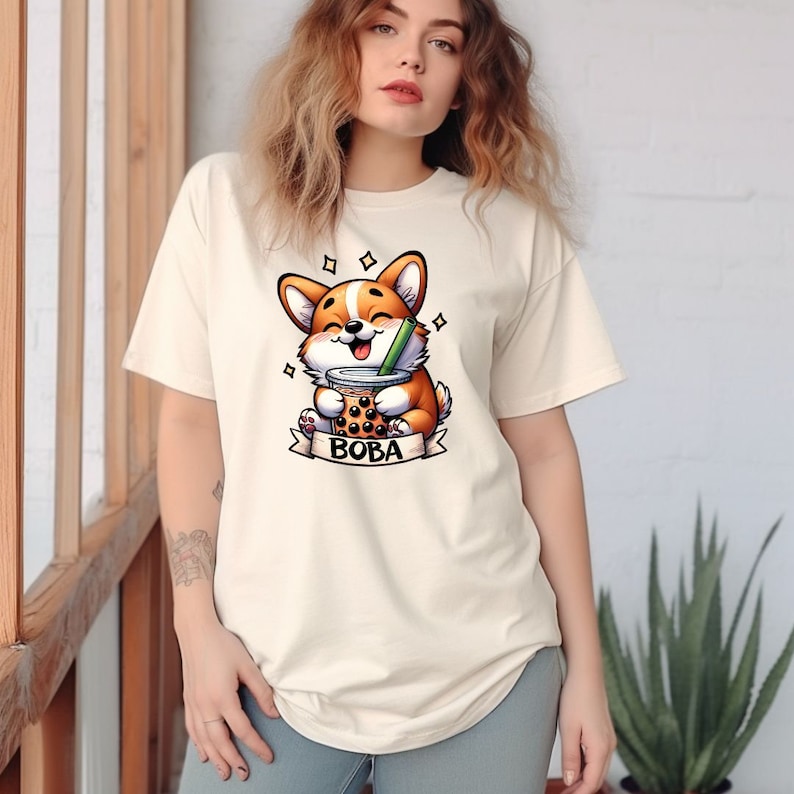 May include: A white t-shirt with a cartoon corgi dog holding a boba tea cup. The text "BOBA" is printed below the dog.