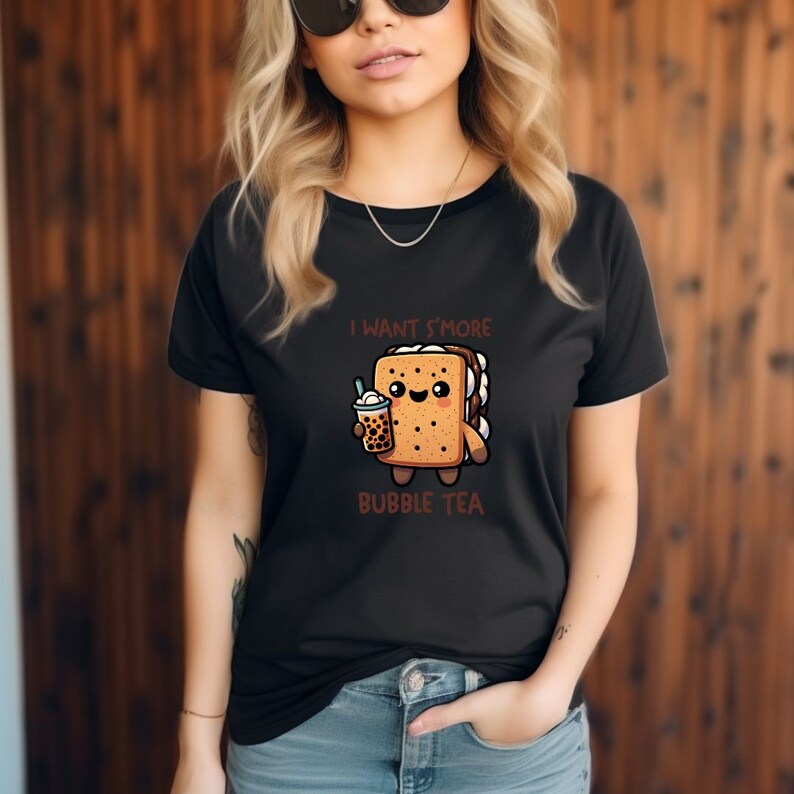 May include: Black t-shirt with a cartoon s'more holding a bubble tea. The s'more has a happy face and the text "I want s'more bubble tea" is printed below the image.